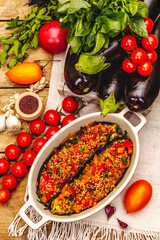Karniyarik traditional Turkish food from stuffed eggplants with minced meat, tomato, greens and sesame seeds