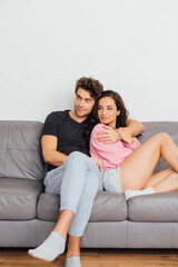Obraz premium Selective focus of handsome man embracing beautiful girlfriend on sofa at home