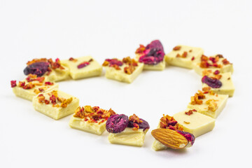 White chocolate with dried berries, fruits and almonds in the shape of a heart.
