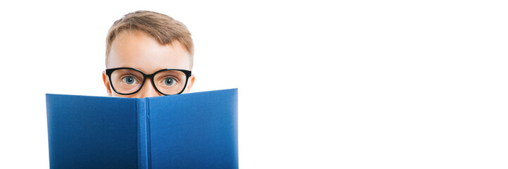 child reads a book against a bright wall