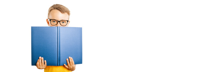 child reads a book against a bright wall