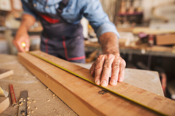 Close up of male hands measuring a piece of wood