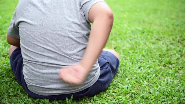 Obese boy feeling back pain, he try to relax his self and dissolve his pain by hand on back
