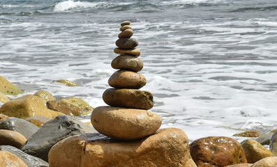 Fototapeta na wymiar una torre de piedras redondas en una playa del mediterraneo