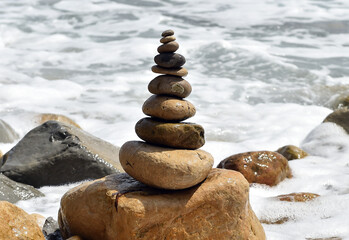 una torre de piedras redondas en una playa del mediterraneo