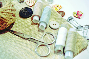 Sewing set of linen fabric, sewing spools, scissors, buttons in beige and ecru colours. Scrapbooking and DIY. Hobby and needle work.