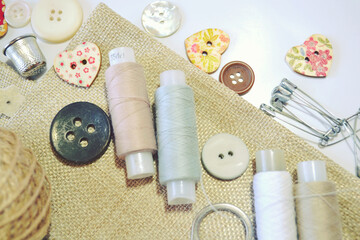 Fototapeta na wymiar Sewing set of linen fabric, sewing spools, buttons in beige and ecru colours. Scrapbooking and DIY. Hobby and needle work.
