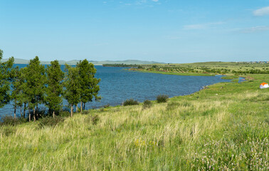 panorama of a beautiful lake with hilly shores. sunny summer day. Lake Shira in Khakassia has mineral, slightly salted water. Lake water has healing properties. 