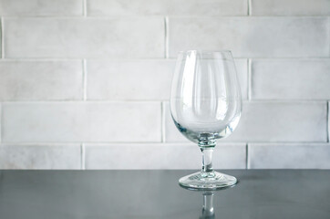 Glass goblet on wall background