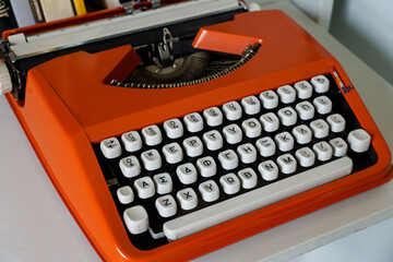 Red vintage Typewrite Machine with greek alphabet on white table.