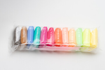 Multi-colored new plasticine in plastic packaging. Rainbow colors plasticine