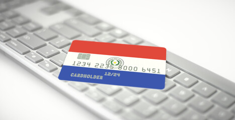 Bank card depicting flag of Paraguay on computer keyboard. Fictional numbers
