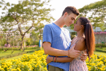 Fototapeta premium Portrait of young multi ethnic couple relaxing together at the park