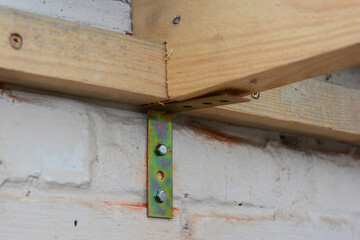 Strengthening roof wooden beams, supporting rafters, gable end bracing with metal corner brackets...
