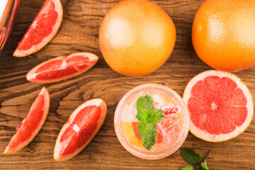 A glass of ripe grapefruit with juice on wooden table close-up