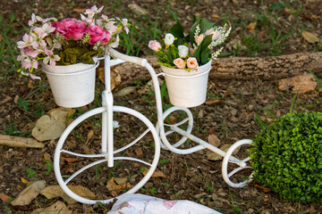 Fototapeta na wymiar Bike artificial imitations adorned with beautiful flowers on the grass. Bicycle decoration.