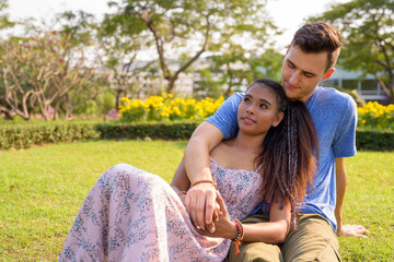 Portrait of young multi ethnic couple relaxing together at the park