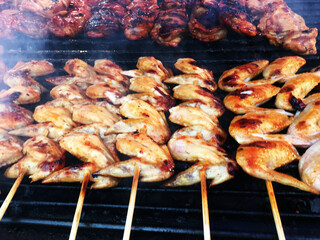 The concept of food on the grill. Chicken wings cooked on coals close up