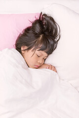 adorable little asian girl sleeping  on the bed with white blanket