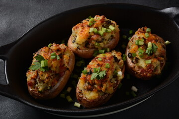 Fried potatoes with mushrooms in a plate/and frying bowl with herbs.