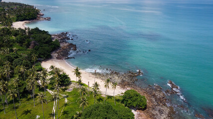 Aerial view of secret beach with palm trees and andaman sea at Lanta island, Krabi, Thailand