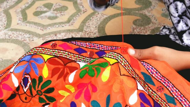Hands of girl woman female in Indian traditional type pattern sewing embroidery pattern close up view,Hands of senior woman, needlework,woman doing embroidery
