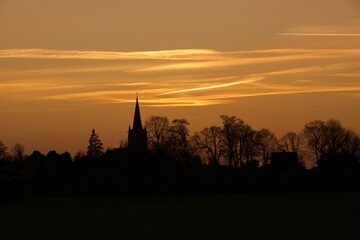 Fototapeta na wymiar Sunset over an old English village church in January.