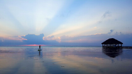 Lone paddle boarder at sunrise