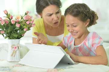 Mother and daughter using tablet together at home