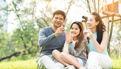 Asian family are happy to picnic, do the lifestyle of parent and daughter in the park. Learn about nature during the long summer holidays with good weather. Concept Health insurance COVID-19