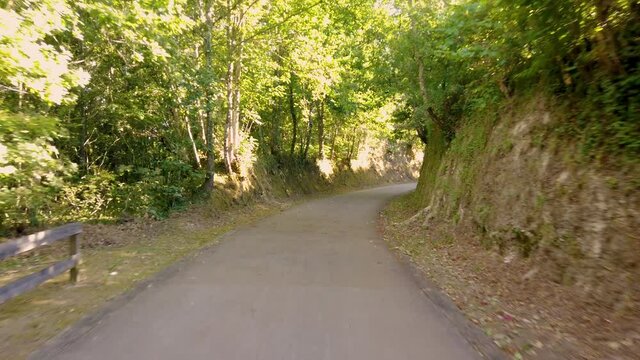 Point of view shot of riding a bicycle at Amarante Cycling Trail in Portugal. Features a wide view of the bike track and the natural scenery as it travels.
