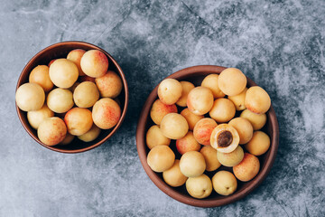 Lots of ripe yellow apricots close up in a crockery on the table