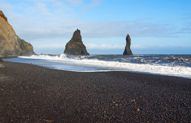 Black basalt sea stacks of Reynisdrangur at Reynisfjara beach, near Vik, Southern Iceland, with...