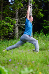 Having a good stretch. Handsome mid Adult man in sports clothing stretching while warming up outdoors in nature. Fitness man stretching his leg muscles outdoors.