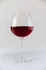 One glass of wine on a gray background