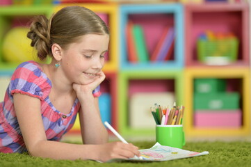 Portrait of beautiful girl drawing picture at home