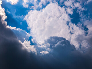 Naklejka na ściany i meble Sun rays shining through thick cloudy sky