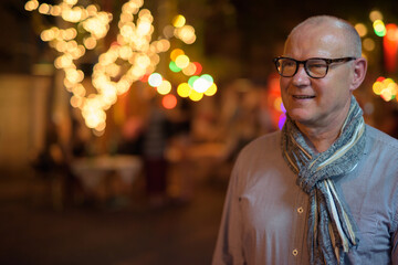 Fototapeta na wymiar Senior handsome Scandinavian tourist man exploring the city streets at night