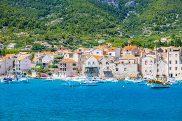 Fototapeta na wymiar KOMIZA, CROATIA, VIS ISLAND coastal town lying on the island of Vis on the Adriatic Sea, view on port, moored boats