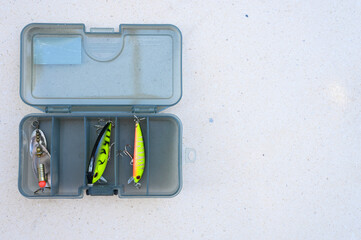 wobblers and fishing lures in a box on the white table background. space for text
