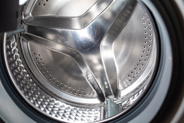 Clean shiny scratch on the drum of the washing machine closeup. The concept of cleaning appliances from scale