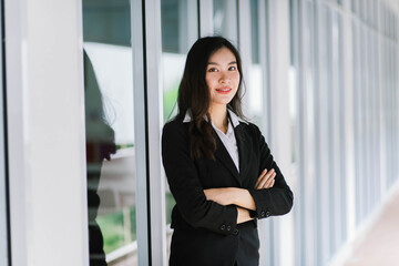A smiling Asian business woman in white shirt crossed her arms