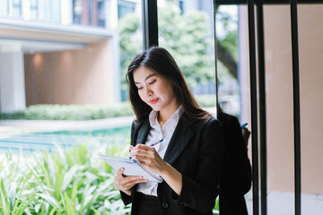 Obraz premium Beautiful young asian woman taking notes