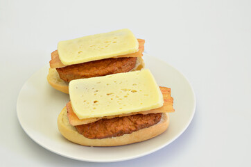 Two Sandwiches with Beef, Bacon and Cheese on white Plate