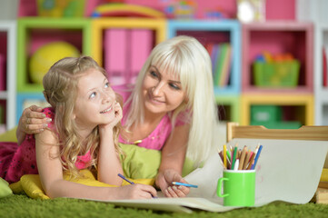 Portrait of girl with mother drawing at home