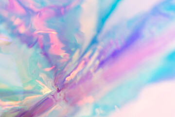 Iridescent blurred holographic texture. Neon colored foil wrinkled material.