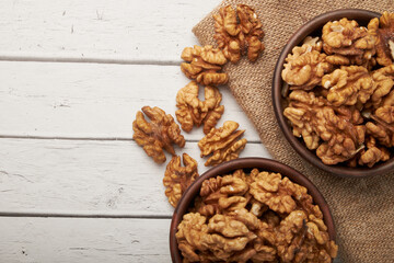 Walnut kernels on a wooden background.