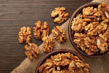 Walnut kernels on a wooden background.