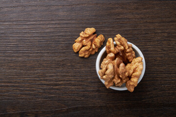 Walnut kernels on a wooden background.