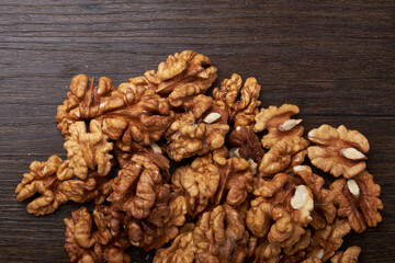 Walnut kernels on a wooden background.
